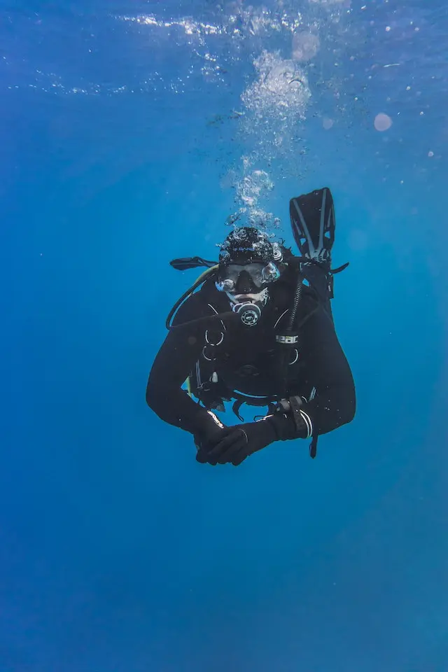 A diver with diving equipment swimming underwater