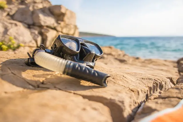 A diving mask with snorkel on the shore