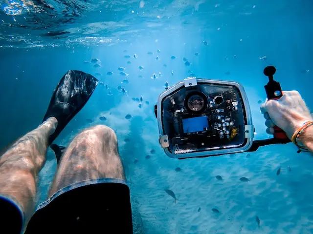 A person holding an underwater camera